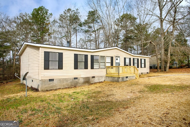 manufactured / mobile home with crawl space, a deck, and a front yard