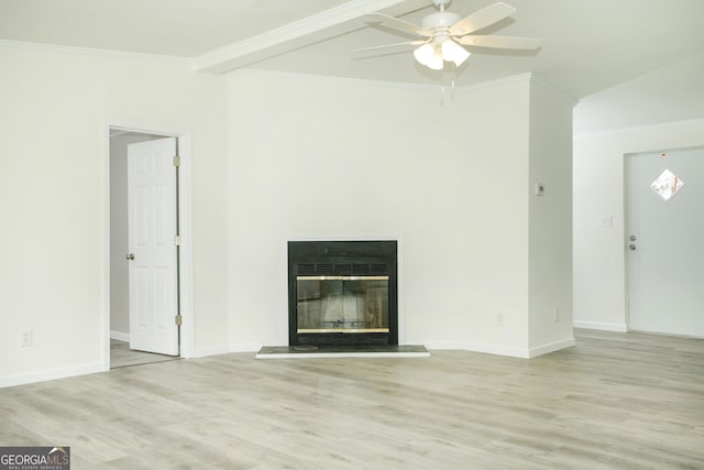 unfurnished living room featuring light wood-type flooring, baseboards, ornamental molding, and a glass covered fireplace