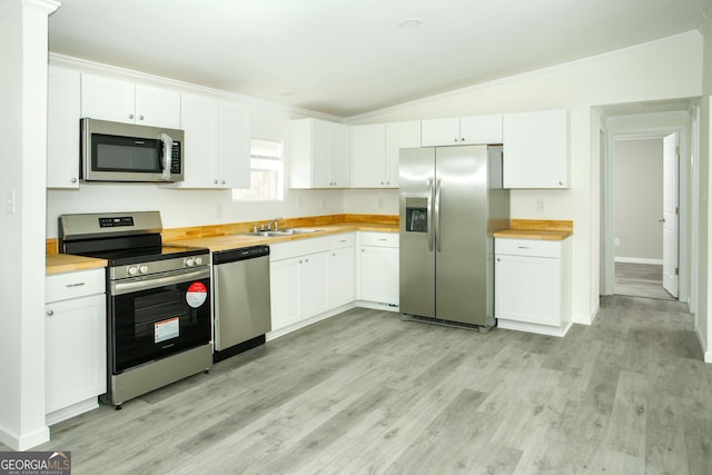 kitchen featuring stainless steel appliances, lofted ceiling, light wood-type flooring, and white cabinets