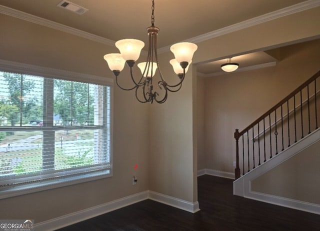 spare room featuring wood finished floors, visible vents, baseboards, crown molding, and a chandelier