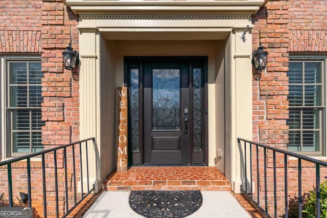 doorway to property featuring brick siding and a balcony