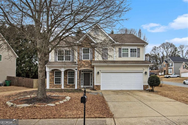 traditional home with an attached garage, a shingled roof, fence, stone siding, and driveway