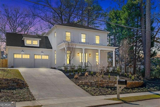 view of front of home featuring covered porch, driveway, an attached garage, and stucco siding