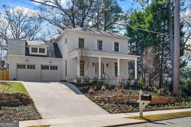 view of front facade with a porch, an attached garage, driveway, roof with shingles, and stucco siding