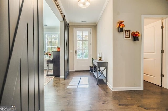 doorway with a barn door, crown molding, baseboards, and wood finished floors