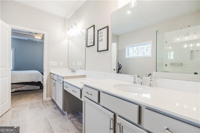 ensuite bathroom featuring ceiling fan, tiled shower, a sink, and double vanity