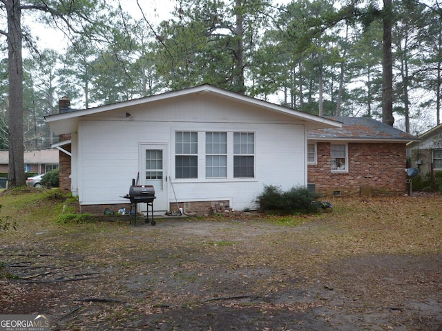 back of house with brick siding and crawl space