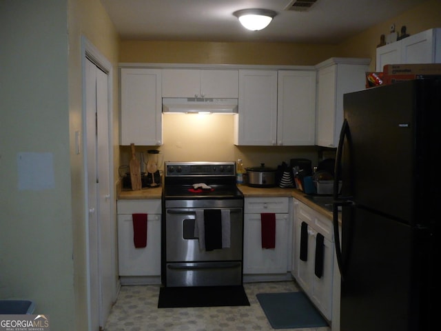 kitchen with under cabinet range hood, electric range, white cabinetry, light countertops, and freestanding refrigerator