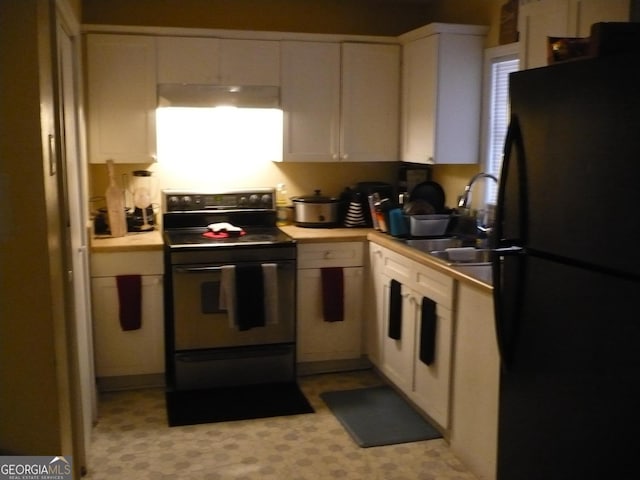 kitchen with black appliances, light countertops, a sink, and white cabinetry