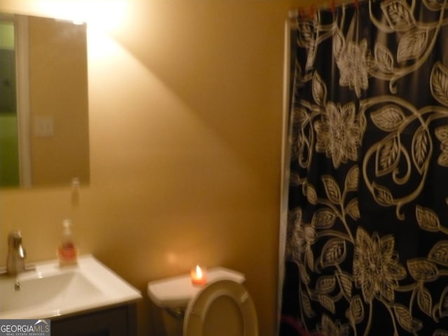 bathroom featuring a shower with curtain, vanity, and toilet