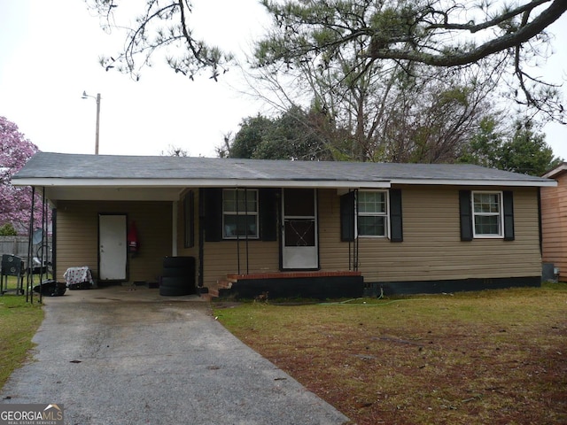 ranch-style house featuring a carport, aphalt driveway, and a front yard