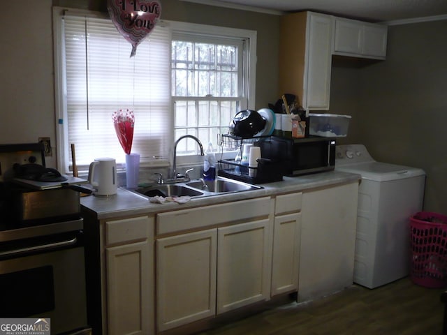 kitchen with stainless steel stove, light countertops, white cabinetry, a sink, and washer / dryer