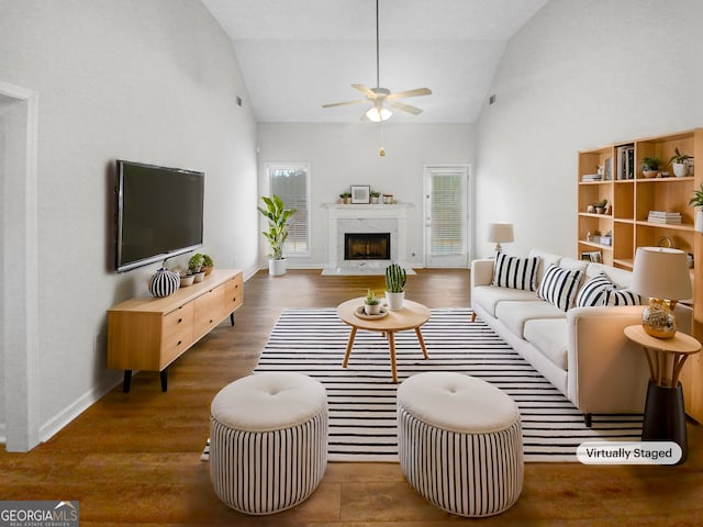 living area featuring high vaulted ceiling, a fireplace, a ceiling fan, baseboards, and dark wood finished floors