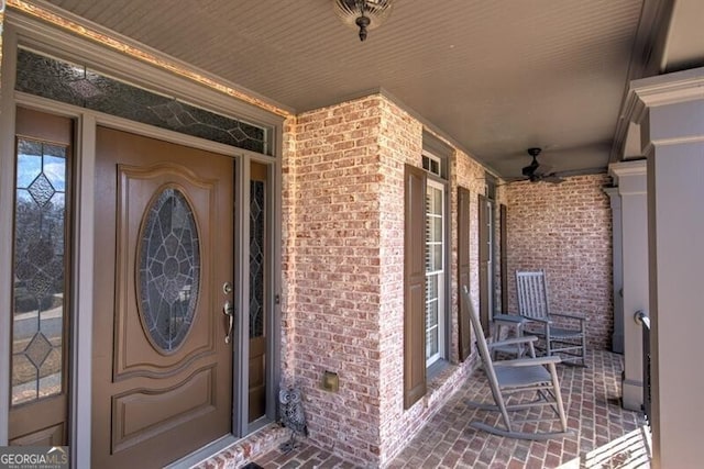 entrance to property with a porch and brick siding