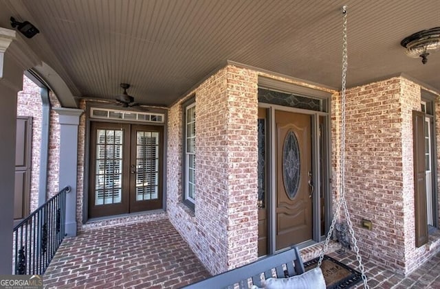 property entrance featuring a ceiling fan, french doors, and brick siding