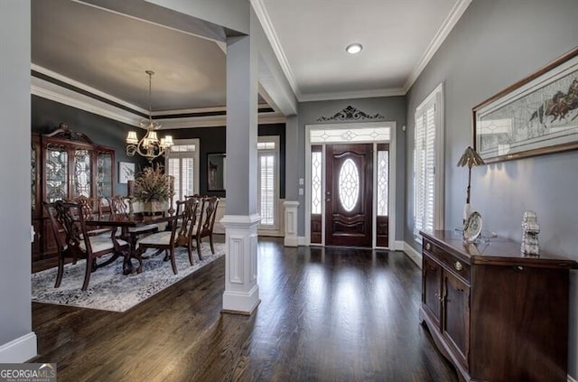 entryway with ornate columns, plenty of natural light, crown molding, and dark wood-type flooring