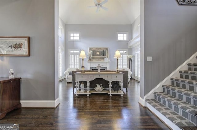 entrance foyer featuring a towering ceiling, baseboards, and wood finished floors