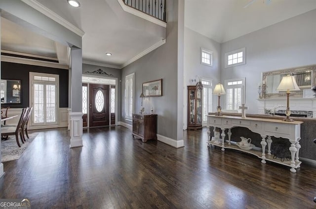 entryway with dark wood-style floors, plenty of natural light, baseboards, and crown molding