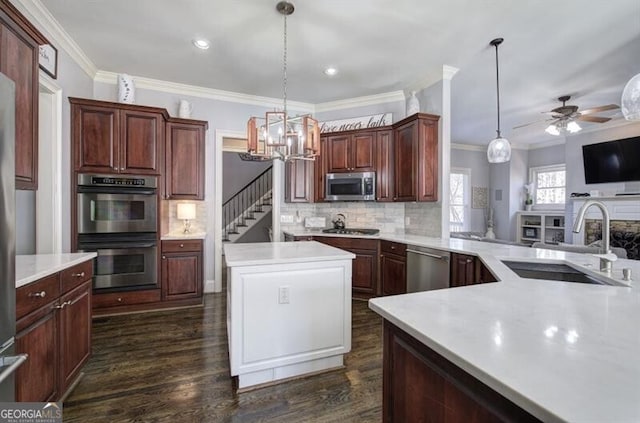 kitchen with dark wood-style flooring, stainless steel appliances, tasteful backsplash, light countertops, and a sink