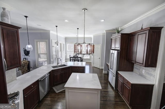 kitchen with tasteful backsplash, a center island, stainless steel appliances, light countertops, and a sink