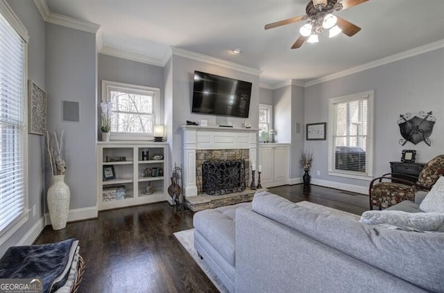 living room with ornamental molding, a fireplace, baseboards, and wood finished floors