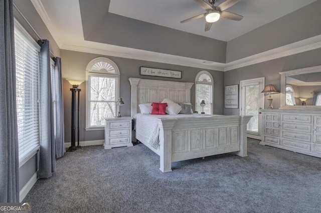 carpeted bedroom with ornamental molding, a raised ceiling, a ceiling fan, and baseboards