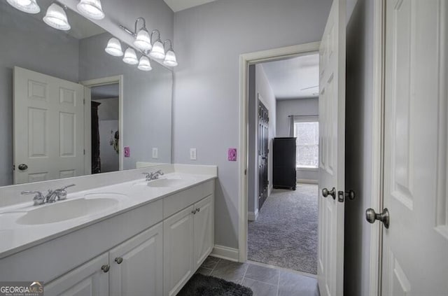 bathroom with double vanity, baseboards, a sink, and tile patterned floors