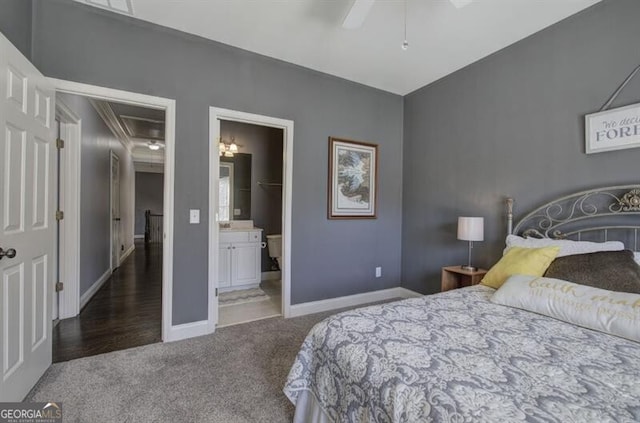 carpeted bedroom with ceiling fan, ensuite bathroom, attic access, and baseboards