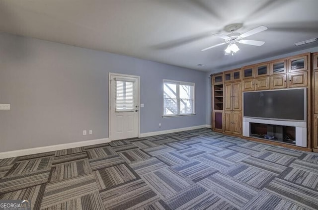 unfurnished living room with a ceiling fan, carpet flooring, visible vents, and baseboards