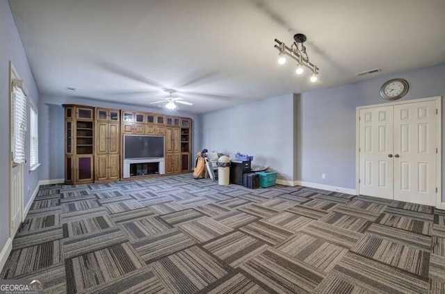 unfurnished living room featuring carpet, visible vents, ceiling fan, and baseboards