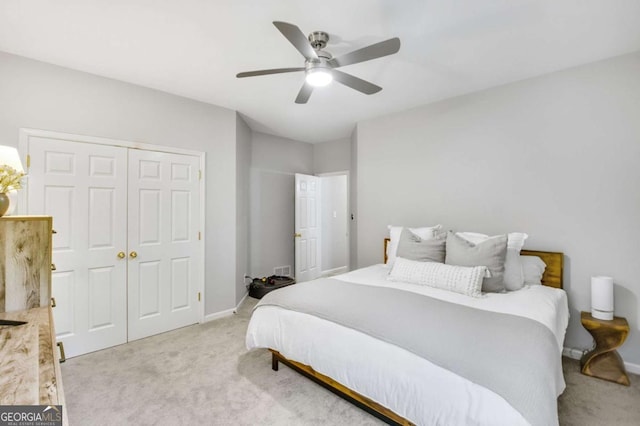 bedroom featuring a closet, light carpet, ceiling fan, and baseboards