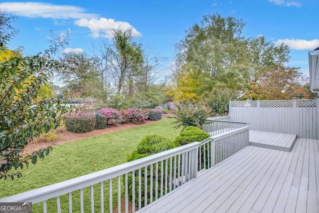 wooden terrace featuring a yard and fence