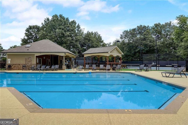 pool featuring fence and a gazebo