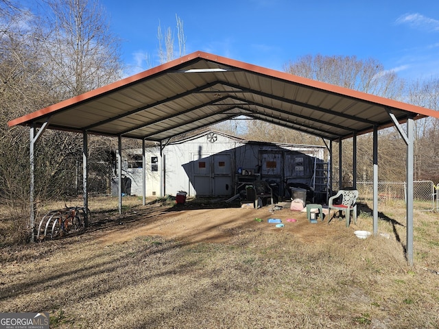 view of car parking featuring dirt driveway, a carport, and fence