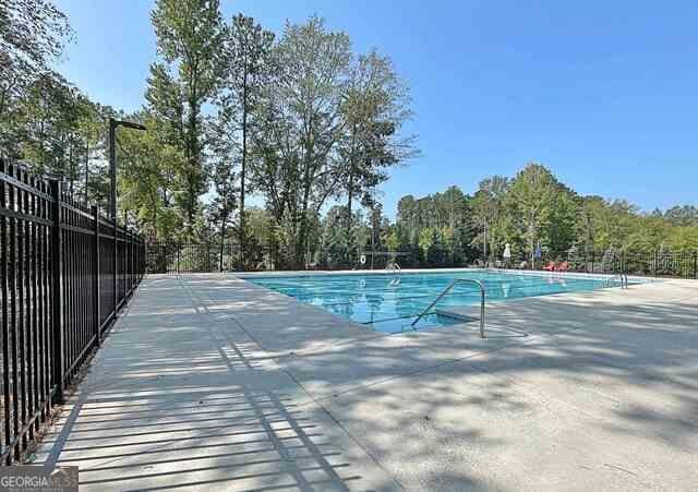 pool with fence and a patio