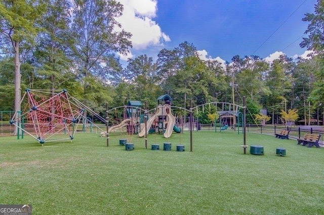 community play area with a lawn and fence