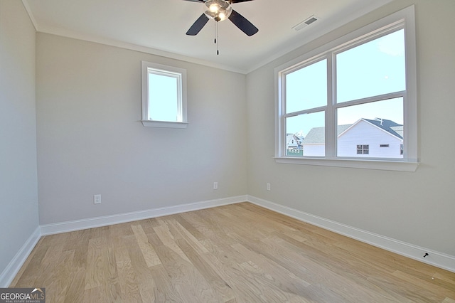 spare room with a wealth of natural light, visible vents, light wood-style flooring, and baseboards