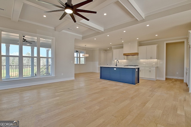 kitchen featuring a center island with sink, white cabinets, open floor plan, light countertops, and light wood-style floors