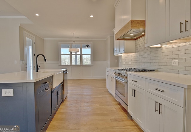 kitchen featuring light countertops, appliances with stainless steel finishes, white cabinetry, and decorative light fixtures