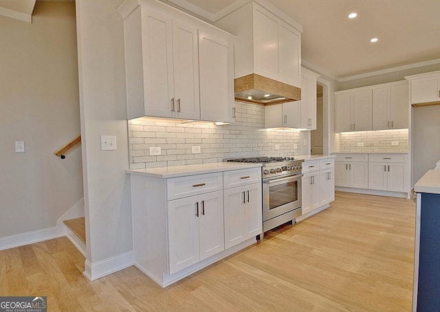 kitchen with light countertops, stainless steel stove, and white cabinetry