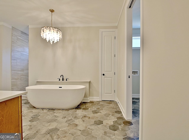 bathroom featuring a freestanding tub, baseboards, ornamental molding, and a notable chandelier