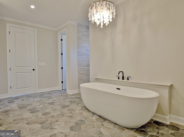 bathroom with recessed lighting, crown molding, baseboards, a freestanding bath, and an inviting chandelier