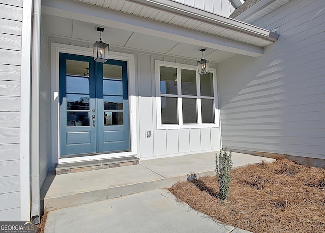 view of exterior entry with board and batten siding and french doors