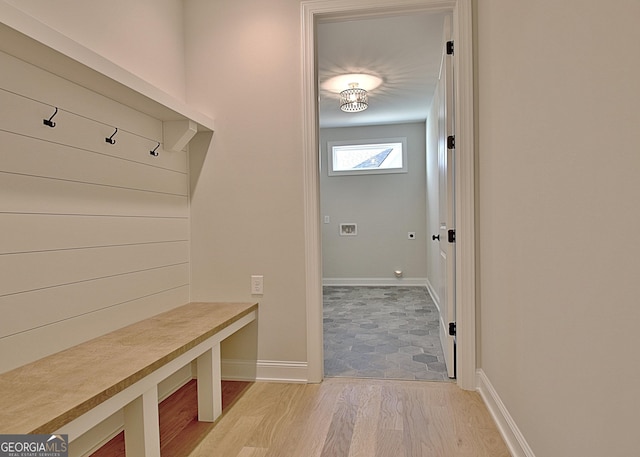 mudroom featuring light wood finished floors and baseboards