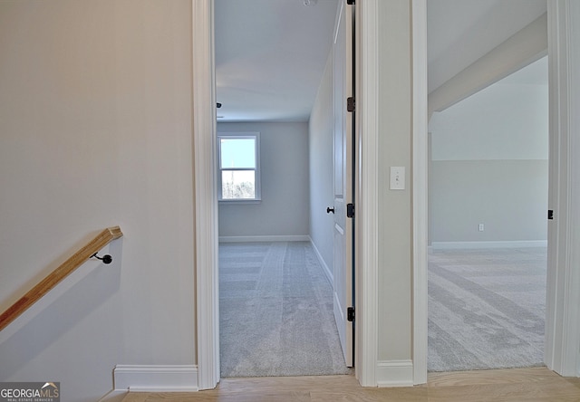 hall featuring light carpet and baseboards