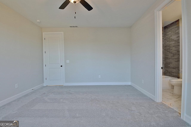 unfurnished bedroom featuring light carpet, ensuite bath, baseboards, and visible vents