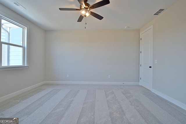 unfurnished room with light carpet, baseboards, visible vents, and ceiling fan