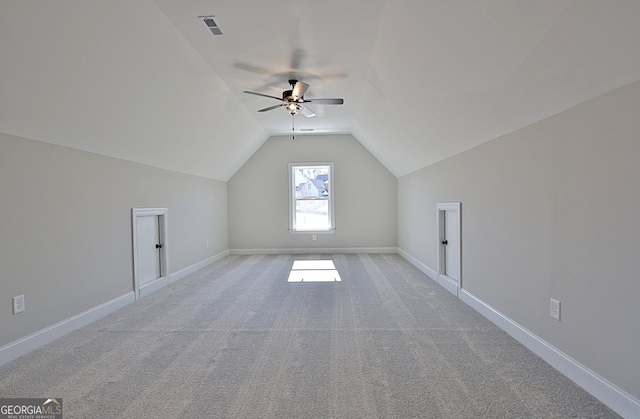 bonus room featuring light colored carpet, lofted ceiling, visible vents, and baseboards