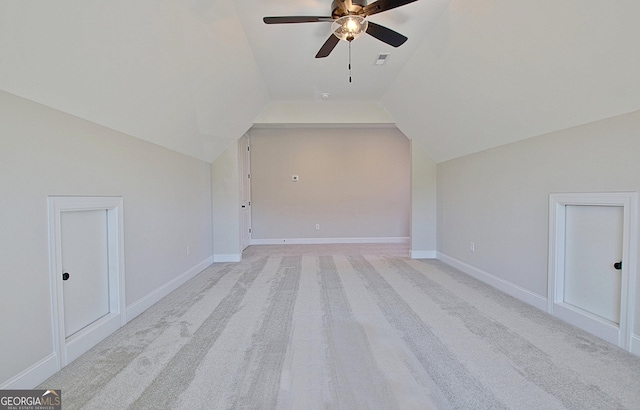 additional living space with lofted ceiling, ceiling fan, light colored carpet, visible vents, and baseboards
