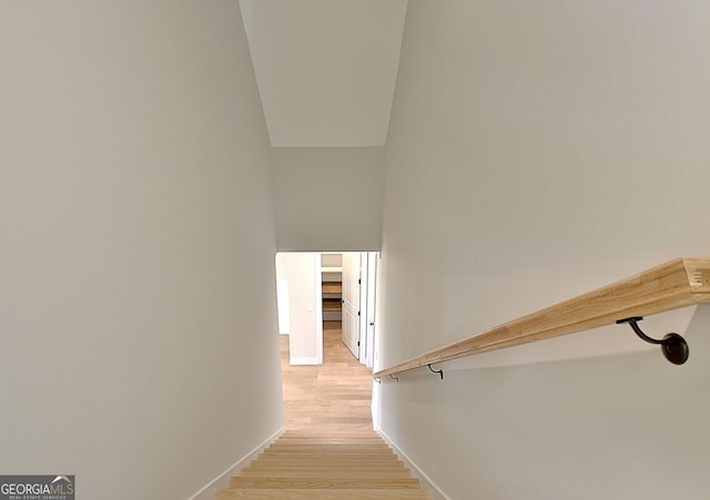 staircase with baseboards and wood finished floors